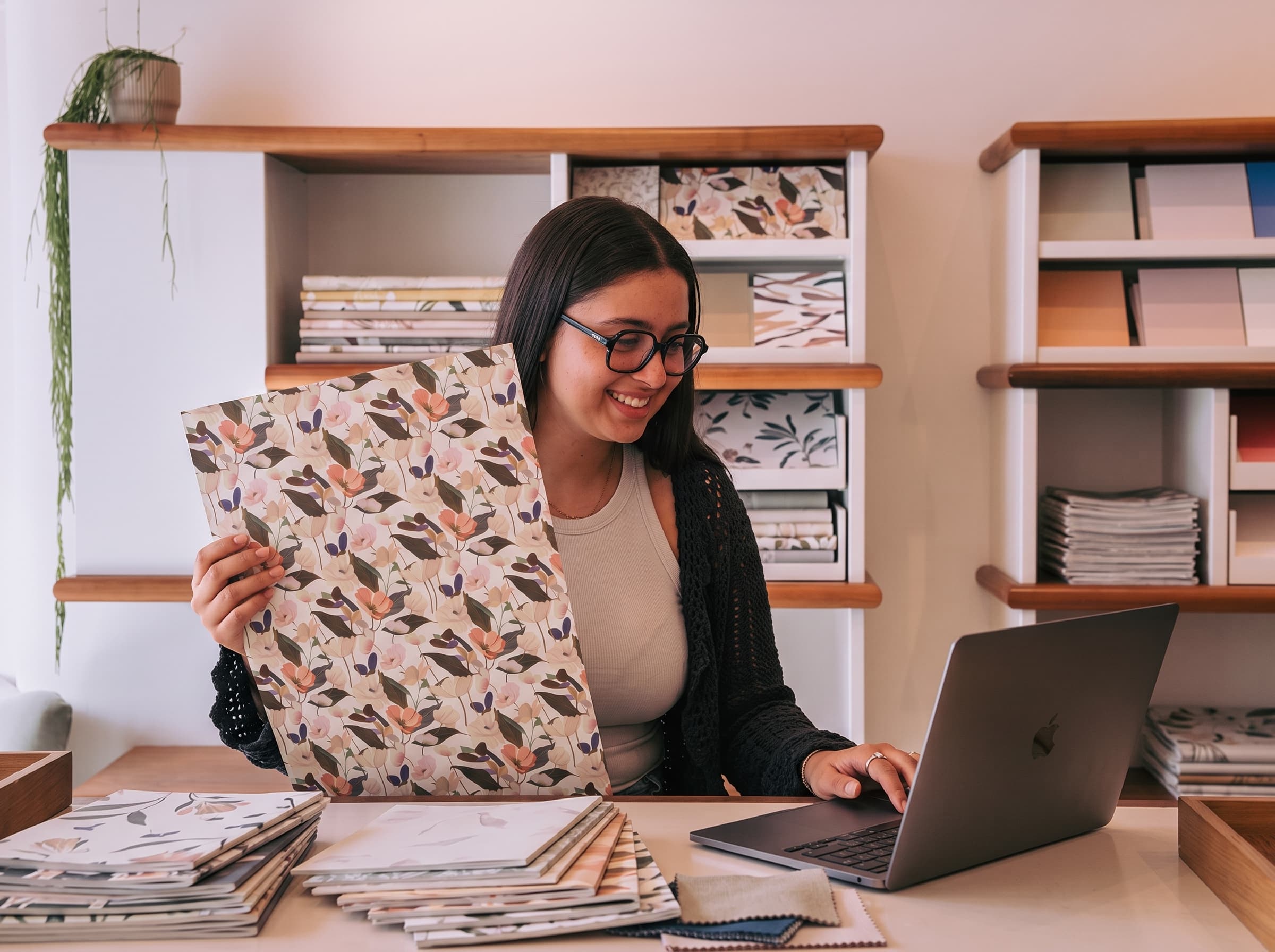 Erismann advisor on a video call holding up a wallpaper sample